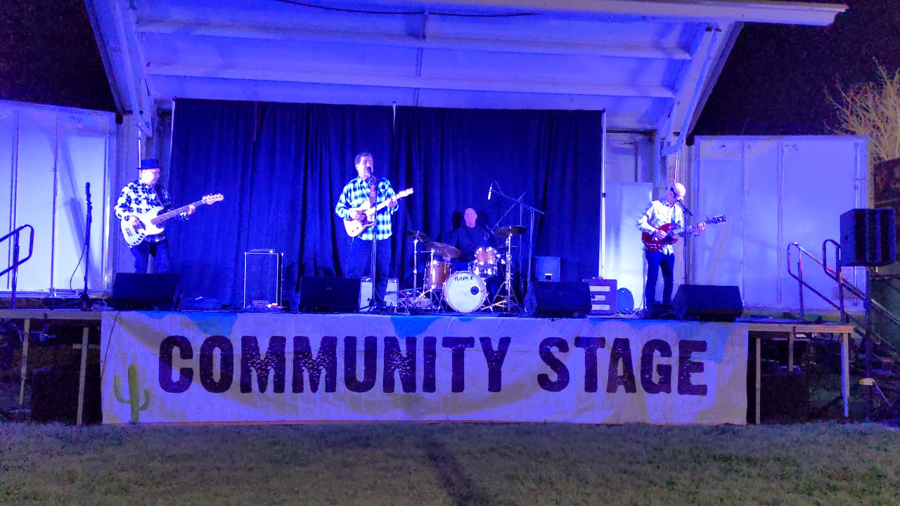 Buffalo Star performing on the Ostrich Festival community stage under blue lights
